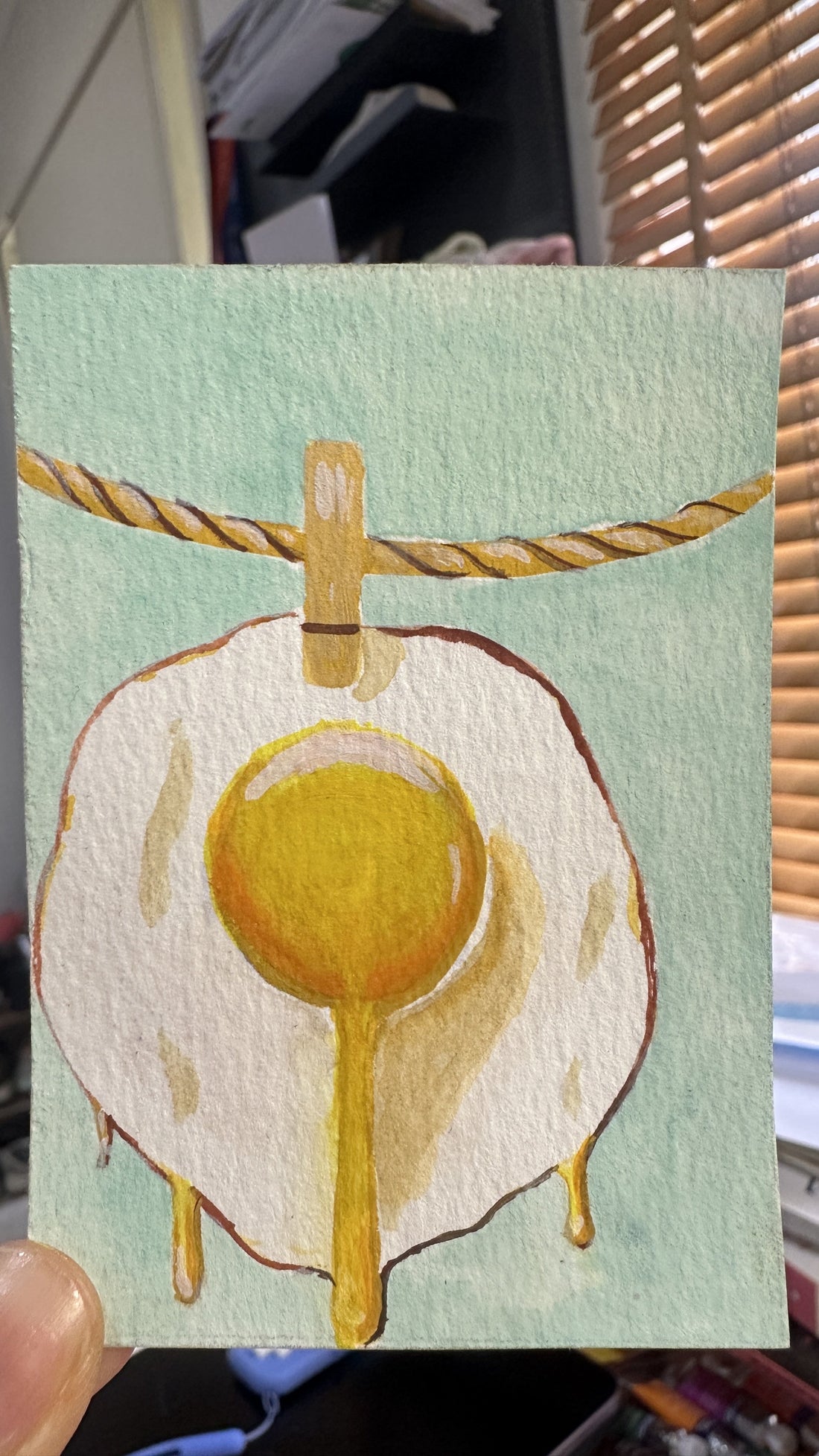 Original ACEO watercolor and gouache painting of a fried egg pendant on a cord