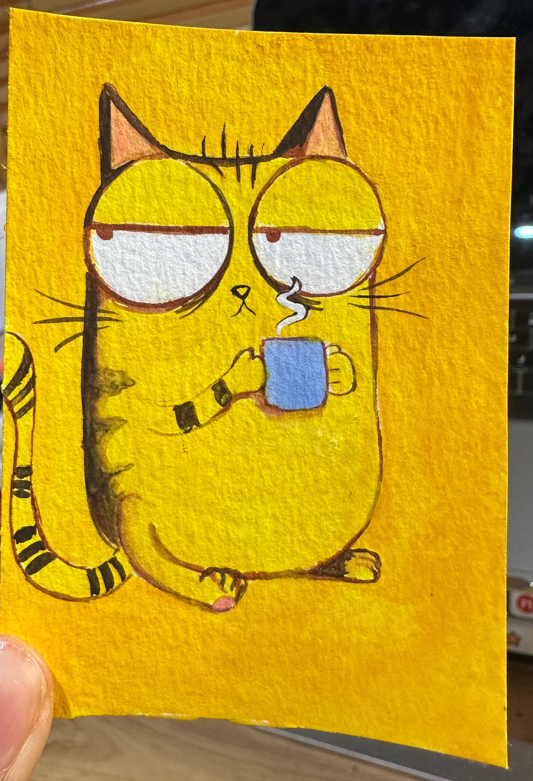 Original ACEO watercolor and gouache painting of a sleepy yellow tabby cat drinking coffee from a blue mug