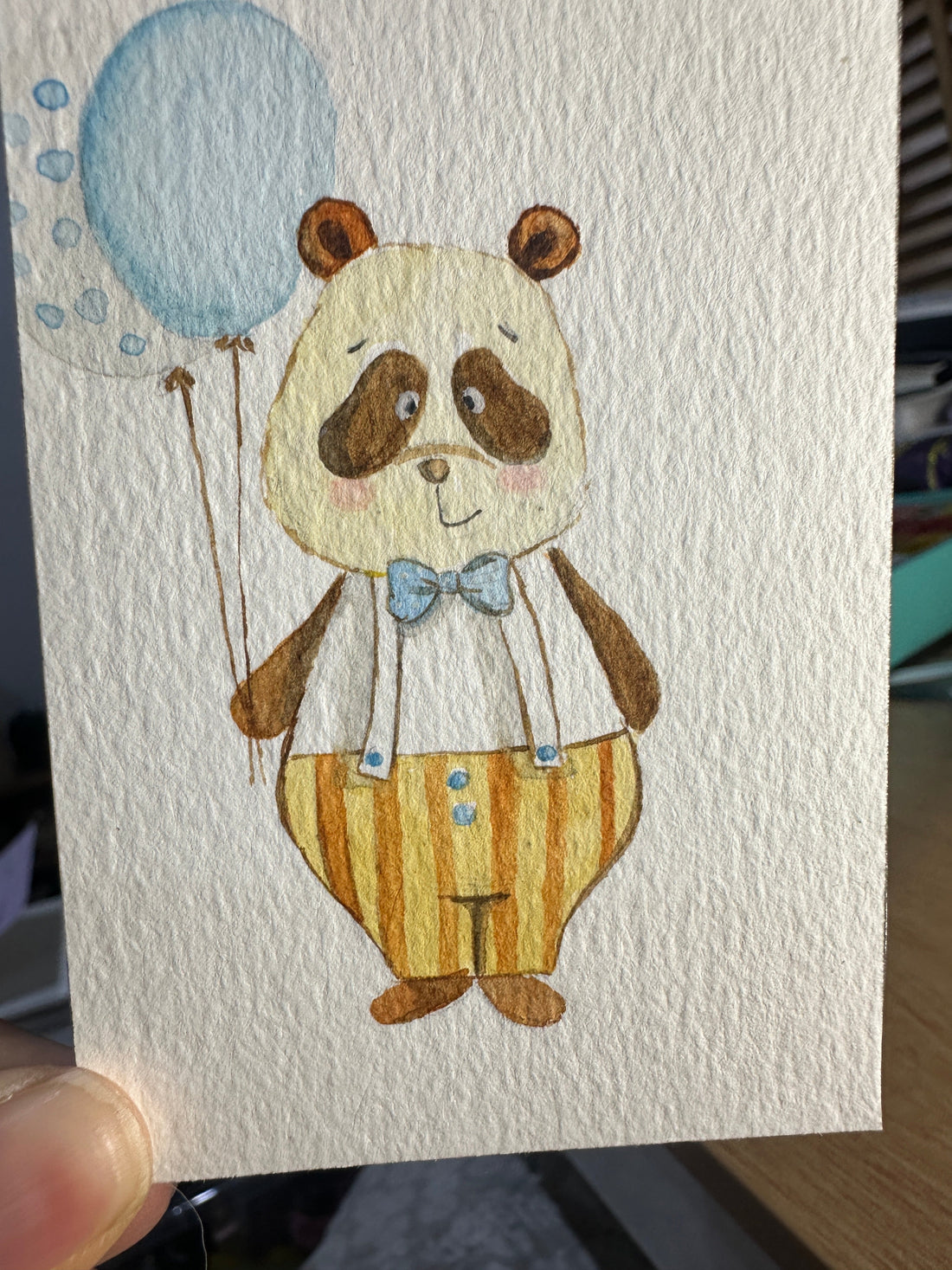 Original ACEO watercolor and gouache painting of a panda cub in striped overalls holding a blue balloon
