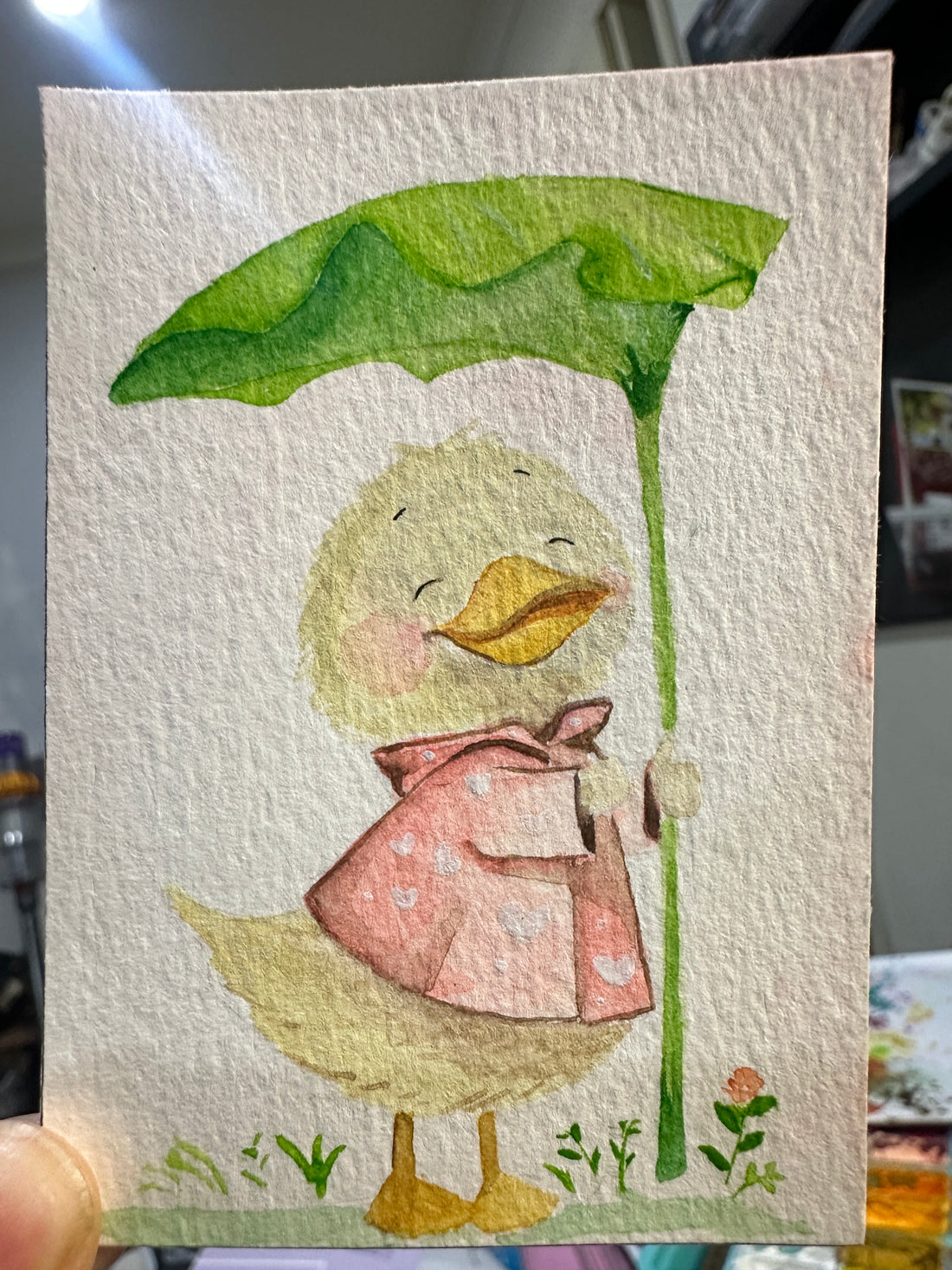 Original ACEO watercolor and gouache painting of a duckling wearing a pink raincoat and holding a leaf umbrella