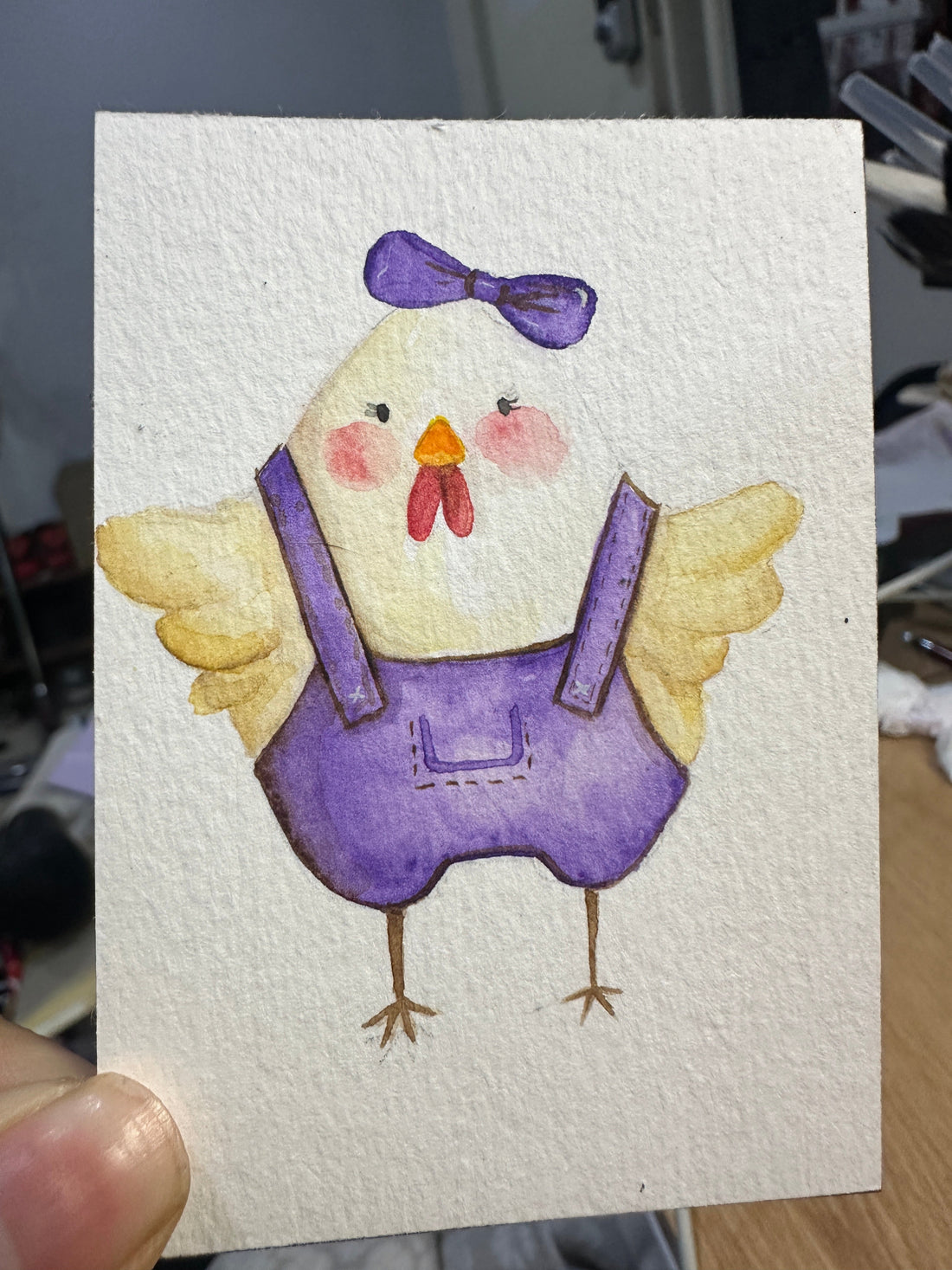 Original ACEO watercolor and gouache painting of a baby chick wearing purple overalls and a purple bow